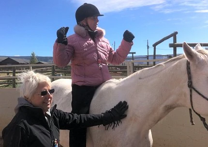 Woman by the horse and on the horse